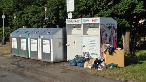 auf dem Bild sind die Altkleidercontainer zu sehen und den dazu gestellte Müll